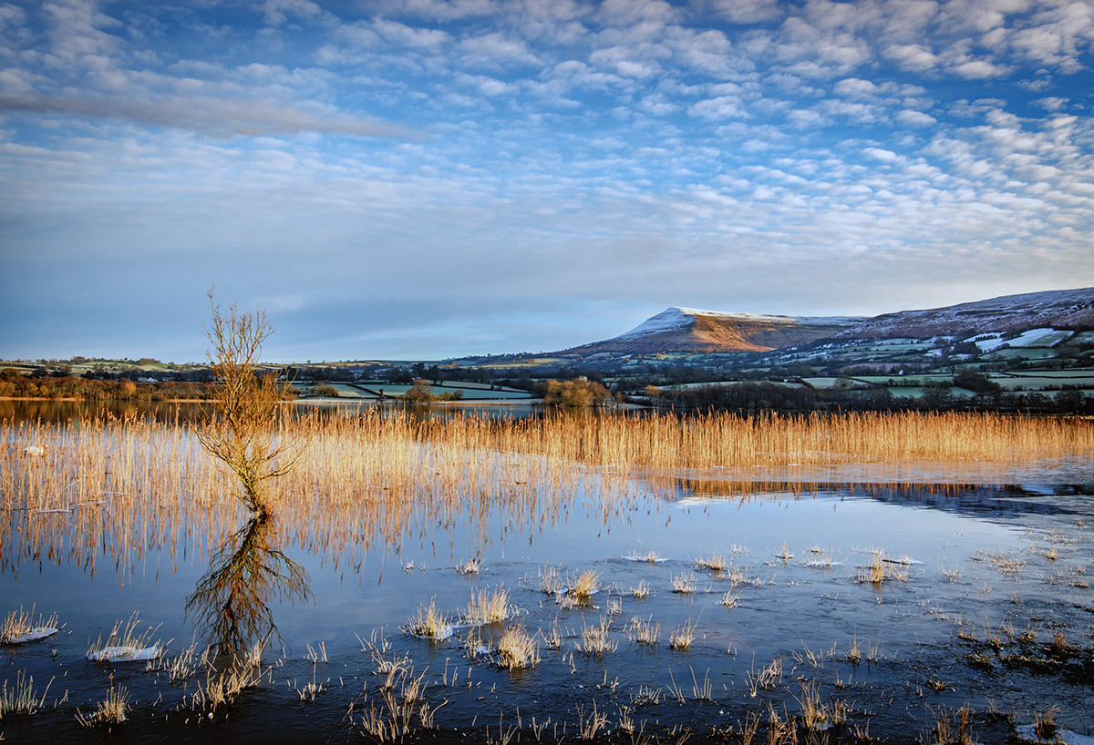 Dawn of Langorse Lake in Wales as the Dawn Sunlight Kisses Talgarth Moutain